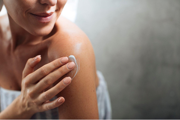 kobieta dbająca o skórę na ciele, smarująca się balsamem do ciała CeraVe